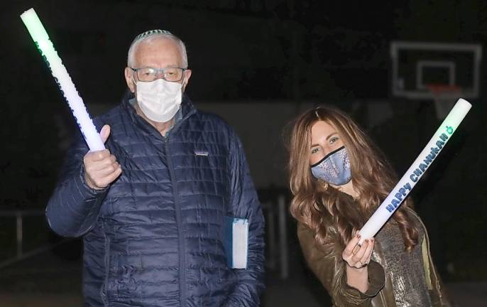 Al Muhlrad of Goshen, pictured with Chana Burston, with Happy Hanukkah Glow Sticks at Chabad’s Hanukkah Drive-in Experience.