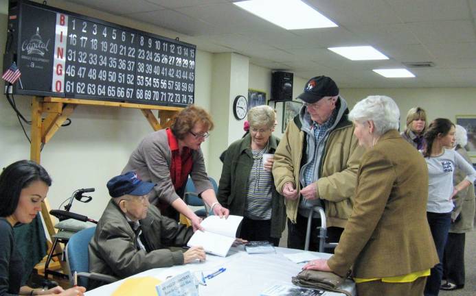 Local author Dominic Kelly signs his book. Standing next to him is co-author MJ Hanley-Goff.