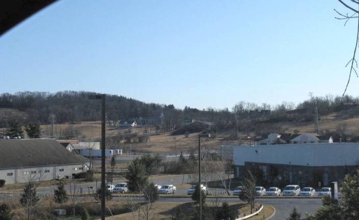 This photo taken from the upper parking lot at 30 Hatfield Lane in Goshen shows the lowlands in the industrial park partially surrounded by hills, a natural amphitheater capable of accommodating the huge crowd that gathered to see the hanging of Jennings' murderers, Jack Hodges and David Dunning. All of the land is part of the former Steward lands where the execution is reported to have taken place. Hatfield Lane, on the other side, rises in height as well. Those hills are also supposed to hold the graves of Steward slaves during the 199 years the family owned the land. (Photo by Ginny Privitar)