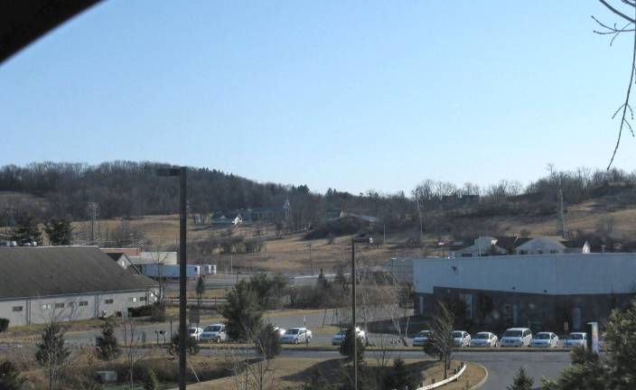 Unhallowed ground This photo taken from the upper parking lot at 30 Hatfield Lane in Goshen shows the lowlands in the industrial park partially surrounded by hills, a natural amphitheater capable of accommodating the huge crowd that gathered to see the hanging of Jennings' murderers, Jack Hodges and David Dunning. All of the land is part of the former Steward lands where the execution is reported to have taken place. Hatfield Lane, on the other side, rises in height as well. Those hills are also supposed to hold the graves of Steward slaves during the 199 years the family owned the land. (Photo by Ginny Privitar)