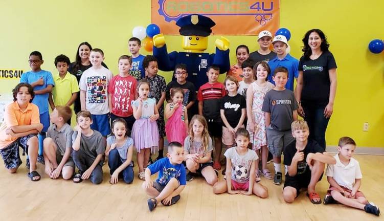Software engineer Monali Monali Verma (right) and Legoland New York's Officer Parks (center back) with students and participants of the recent open house (Photo provided)