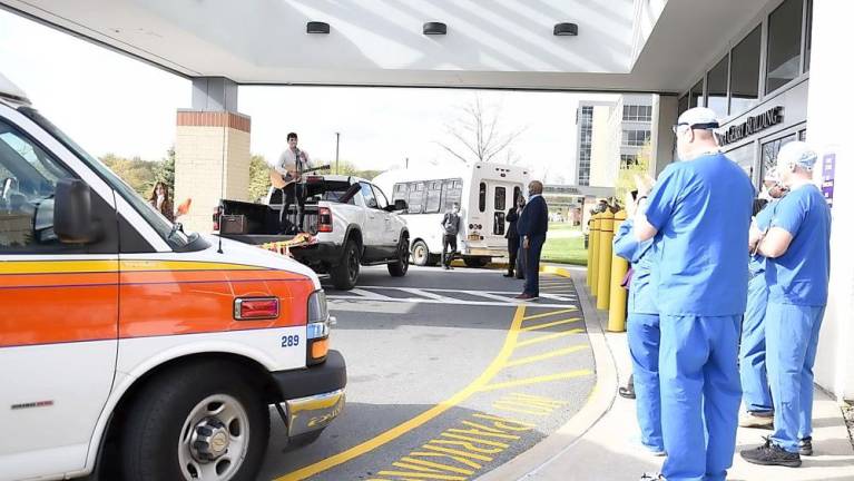 Duvy Burston, 17, plays music in front of Orange Regional Medical Center, as caregivers look on at Chabad’s Honk for Heroes Car Parade.