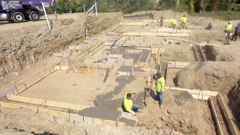 Workers prepare the foundation of a semi-attached single-family home this week at The Greens at Chester.