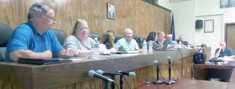 At dias, left to right: Larry Dysinger; Dot Wierzbicki; Jackie Elfers; Don Serotta, chair; Alexa Burchianti, secretary; Dave Donovan, planning board attorney; Carl D'Antonio; Mark Robertson; and Bob Conklin. Seated is the engineer substituting for town engineer Al Fusco.