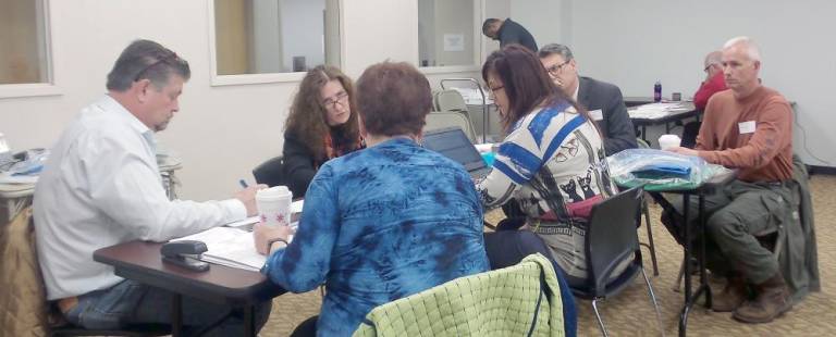 Seated around the table at the Orange County Board of Elections as ballots were counted are Chester Supervisor Bob Valentine, senior registration specialist Ada Kirkpatrick, attorney Paul Ernenwein, newly elected Chester councilman Tom Becker, coordinator Susan McDonald, and supervisor candidate Sue Bahren.