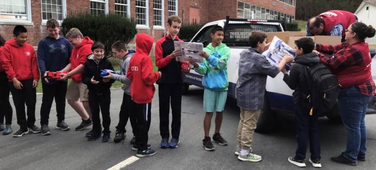 Team members formed a “bucket brigade“ to pass the Lowe's-donated equipment and tools into their storage space at the C.J.Hooker School.