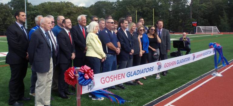 Dignitaries gather in front of the ribbon.