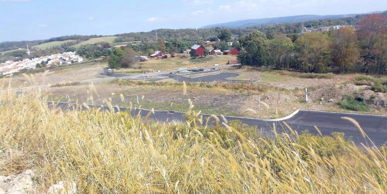 The rooftops of Whispering Hills can be seen at a distance.