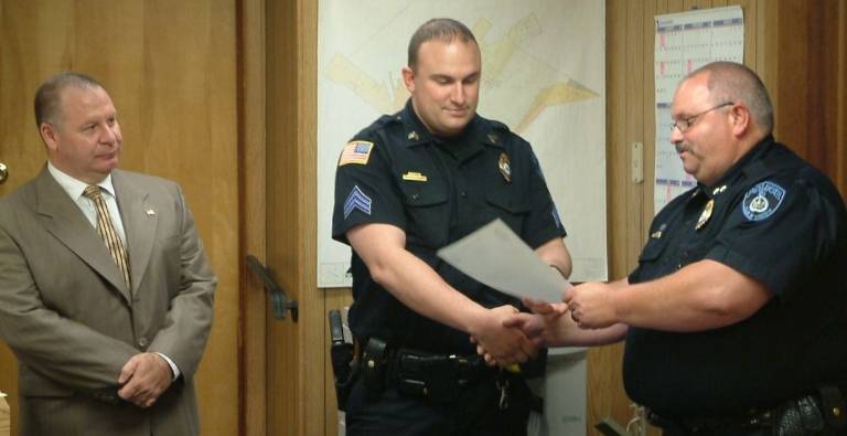 Chester Village Board briefs Photo courtesy Detective Timothy McGuire Brad Natalizio is congratulated for his achievement in earning a master's degree in criminal justice. Police Chief Peter Graziano shakes his hand as Mayor Philip Valastro looks on.