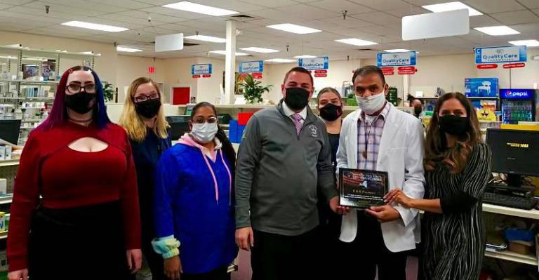 Samir and Hatel Shah, right, with Sentor Mike Martucci, who gave them an Empire Award for community service. K&amp;K Pharmacy staff surround them.