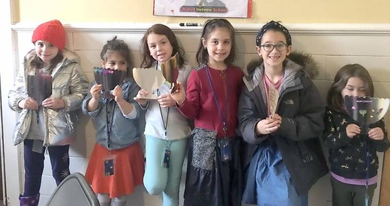 Children holding the cards they wrote and decorated for a holocaust survivor.