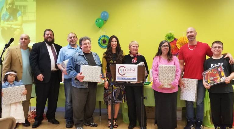 Fidget spinners and fiesta a treat for 'moving up' class at Hebrew school Chabad presents gifts to Chabad Hebrew School parent and community volunteers (from left): Guy Einav of Monroe (four-year old Libby holding Daddy’s gift), Rabbi Pesach, Philip Reich of Highland Mills, Sid Herhkowitz of Monroe, Chana Burston, Iris Sasson of Monroe, Hillary Cohen of Middletown, and Seth and Conner Ingber of Goshen (Photo provided)