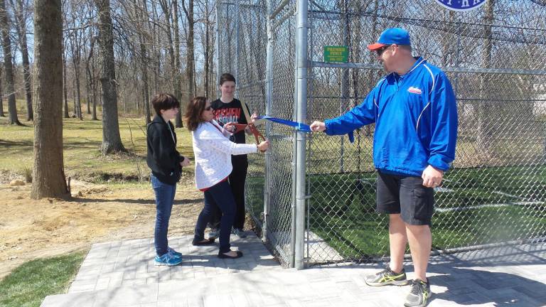 New batting cage honors Art Borin Kay, Tim and Karen Borin with Drew Whitney cut the ribbon to Goshen’s new batting cage (Photo by Frances Ruth Harris)