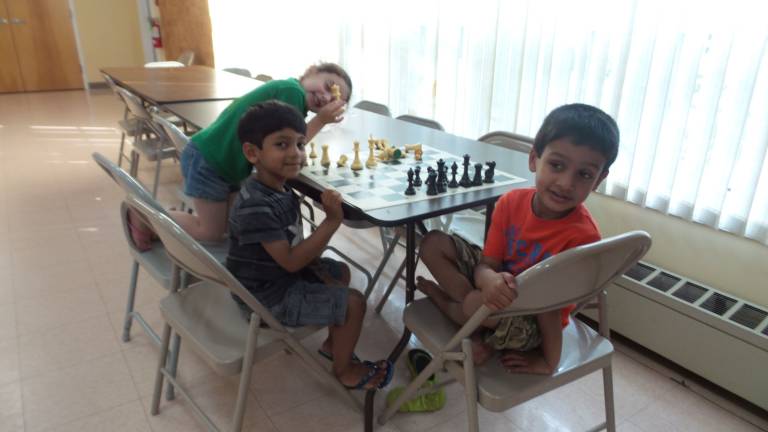 Check mate! From left: Naomi Aclin, Saket Dintakurti, Arnav Sinha playing chess at the Goshen Senior Center (Photo by Frances Ruth Harris)