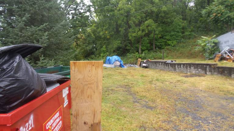 Neighbors say two garbage dumpsters in front of the property overflow with trash (Photo by Frances Ruth Harris)