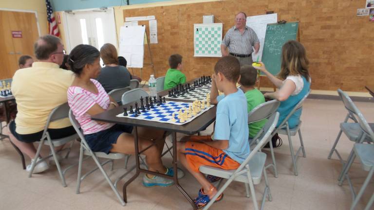 Check mate! Ed Dubin of Florida, an exceptional chess player and former history teacher, leads the chess class at the Goshen Senior Center (Photo by Frances Ruth Harris)