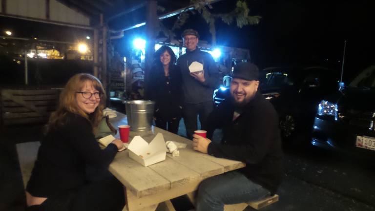 A picnic table provided a nice meet-up spot for consuming cheese steaks from the United Cheese Steaks of America food truck. Pictured are Mary Stephens of Middletown, Heather Candella of Chestnut Ridge in Rockland County, and Toni Leone and Jim Hayes. (Photo by Frances Ruth Harris)