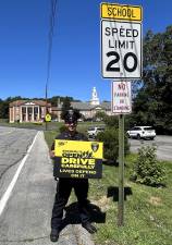 Village of Goshen Police Officer Tyler Gennarelli with a AAA awareness sign. (Photo provided)