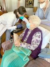 Orange County Health Commissioner Dr. Irina Gelman vaccinates Sophia Bott at her Greenwood Lake home on Sunday, March 21. Seated behind Bott is one of her caregivers, Karen Eskholme.