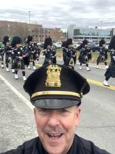 Town of Goshen Chief of Police James Post poses in front of the bagpipers at the Mid-Hudson St. Patrick’s Parade.
