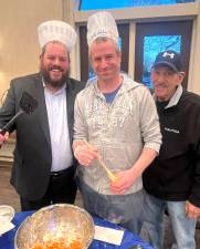 Rabbi Pesach Burston makes traditional potato latkes with Eric Benezra and Steve Reich at Chabad’s “Latke Sizzle” event.