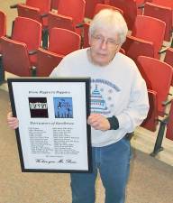 Roy Reese displays the picture given to him by the cast and crew of Mary Poppins commemorating his first 30 spring musicals.