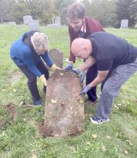 Ray Quattrini, from the Slate Hill Cemetery Board of Directors, and Goshen Historian Ed Connor helped teach Goshen BSA Troop Eagle Scout candidate Sam Lieneck the correct way to raise and clean the headstones. Provided photos.