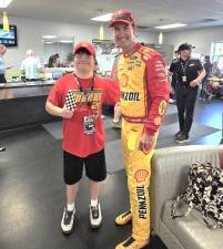 Nathan Dershem with his hero, NASCAR champion Joey Logano, at the Poconos Raceway. Photo provided.