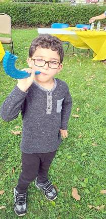 Young Grayson from Monroe sounds his shofar on the grounds of Chabad of Orange County on Main Street in the Village of Goshen.
