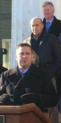 L. Todd Diorio, president of the Hudson Valley Building Trades Council, stands behind Orange County Executive Steve Neuhaus in front of the 1841 Courthouse in Goshen on Wednesday afternoon. Harry Porr, the county's director of operations, is behind him. (Photo by Edie Johnson)