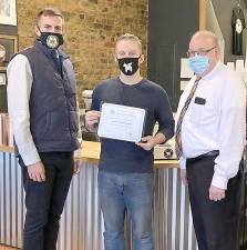 Assemblyman Colin Schmitt presents the Small Business of the Month Award for December to Valkyrie Coffee Roasters owner and roastmaster Dakota Rudolph alongside Chester Town Councilman Robert Courtney. Provided photo.