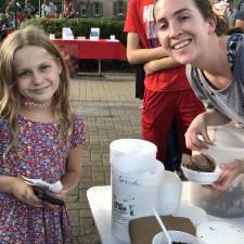 Patience pays off: Marissa Montiro, 8, of Goshen can’t wait to dig into the free ice cream provided by What’s the Scoop ice cream stand. Owner Kristen Mulroe is pictured at right.