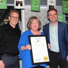 Susan Armistead stands between OC Legislator Jonathan Redeker (left) and Sen. James Skoufis holding a copy of her proclamation.