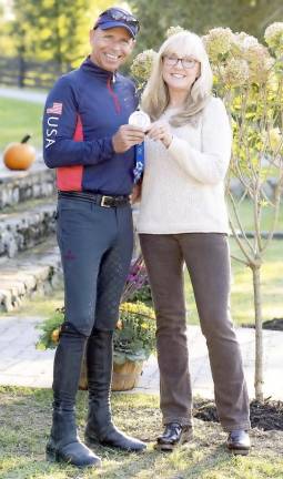 Five-time Olympic Dressage Champion Steffen Peters holding his Silver Medal, poses with Deirdre Hamling.