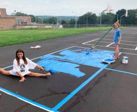 Girls used Goshen School colors to paint the recess area at the Goshen Intermediate School.