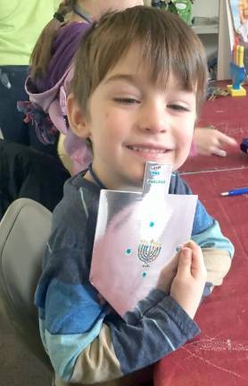 Jasper holding the card he wrote and decorated for a holocaust survivor.