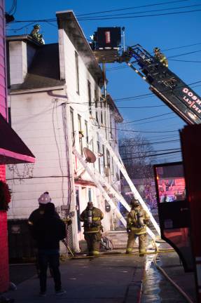 Goshen, NY Jan 13 2018. Firefighters on the roof of multi-dwelling aparment block.