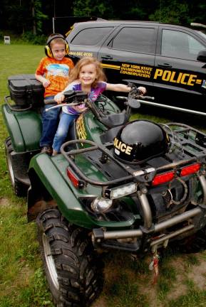 Vroom-Vroom: Addison Trimble, 4, tries out a New York State Police ATV, with T.J.Wright, 7, sitting shotgun (Photo by Ed Bailey)