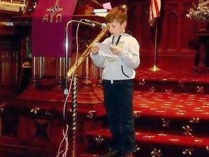 Vlodjo Mykula, 8, reads from the Scriptures during the prayer service.