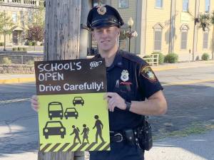 Village of Goshen Police Officer Evan Metakes placed a “Schools open-drive carefully” poster.