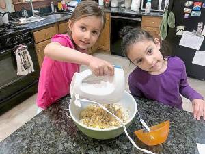 Isla and Arysa Rielly practicing the culinary arts at their grandparents' home in Chester by making oatmeal cookies for their grandfather's birthday.