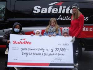 Mary Sumter, on the far left, accepted the check from Safelite Autoglass for the Goshen Ecumenical Food Pantry. Helping her hold that big check is the Ellis family—Ashley, 3, Emily, 9, Kelsey, 4, and Mom Jennifer. Dad Patrick was busy with distributing groceries and missed the photo moment.