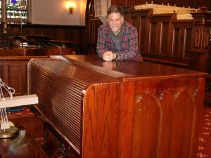 Jonathan Hall, director of music at The First Presbyterian Church in Goshen, shown with the Austin organ, installed in 1931, which is now in need of repairs. Needing repairs, though, isn’t stopping Hall from providing music for upcoming holiday services at the church. There’s a whole assortment available for the music director to present to the congregation. Photo by Geri Corey.