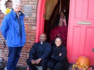Goshen Village Historian Edward Connor stands with happy congregants of the African Union Methodist Presbyterian Church, located at 207 Main St. in Goshen. Seated are Pastor Brazley Young and Marcia Terrell and in back, Mary Sumter with her daughter Jenester Collins behind her. Alongside the Village Historian is the plaque designating the church as listed on the National Register of Historic Places. Photo by Geri Corey.