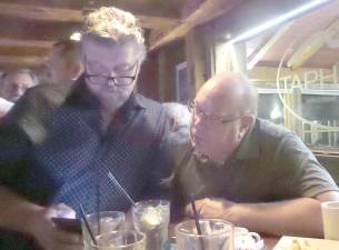 Incumbent Bob Valentine (left), who's leading in the race for supervisor; and Robert Courtenay, a newcomer who won his bid for town board, check results at the Sugar Loaf Tap House Tuesday night.