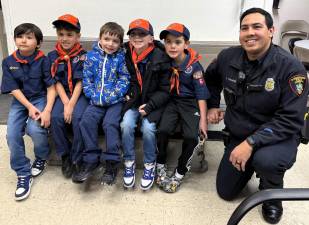 Officer Stephan Sookdeo poses with members of Cub Scouts Pack 63