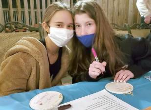 Yirshalem Pinkus of Sugar Loaf and Molly Berman of Warwick write messages of hope for sick children at Chabad’s CTeen giving event “Tiles for Smiles” with Rabbi Pesach and Chana Burston of Chabad of Orange County. Provided photos.
