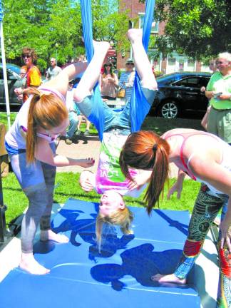 Anna Lisa Miely, 9,of Warwick, tries out some moves at the Flexibility in Flight exhibit. She is assisted by Katie Adams (left) of Southfields and Katie Struble of Slate Hill.