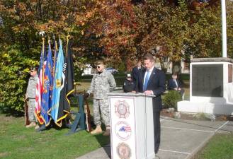 As Village of Goshen Mayor Scott Wohl spoke to the public, two veterans stood guard over the flags during Veterans Day ceremonies. “We can protect our freedom simply by maintaining it,” the mayor said in his remarks. “By voting, volunteering, teaching and, importantly, by speaking out against injustice wherever we find it.” Photos by Geri Corey.