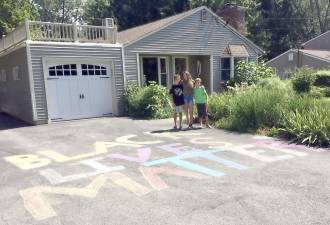 The Mullally cousins - Bryce, 11, Devon, 13, and Austin, 11 - took chalk to their grandparents’ driveway on Oxford Road in Goshen to take part- in their own way - in the Black Lives Matter movement. Photo by Beth Quinn.